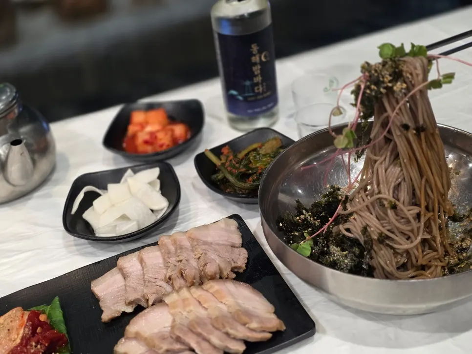 Chopsticks lifting a bunch of perilla oil makguksu noodles