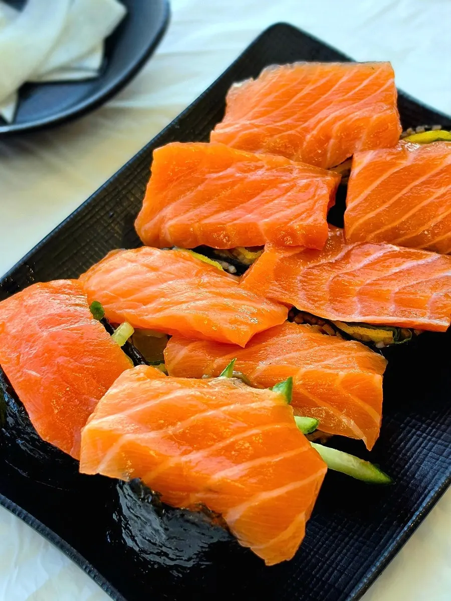 Thick slices of raw salmon on top of the buckwheat gimbap
