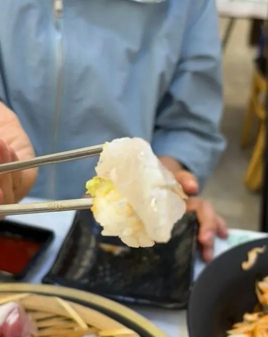 Picking up a piece of sashimi
