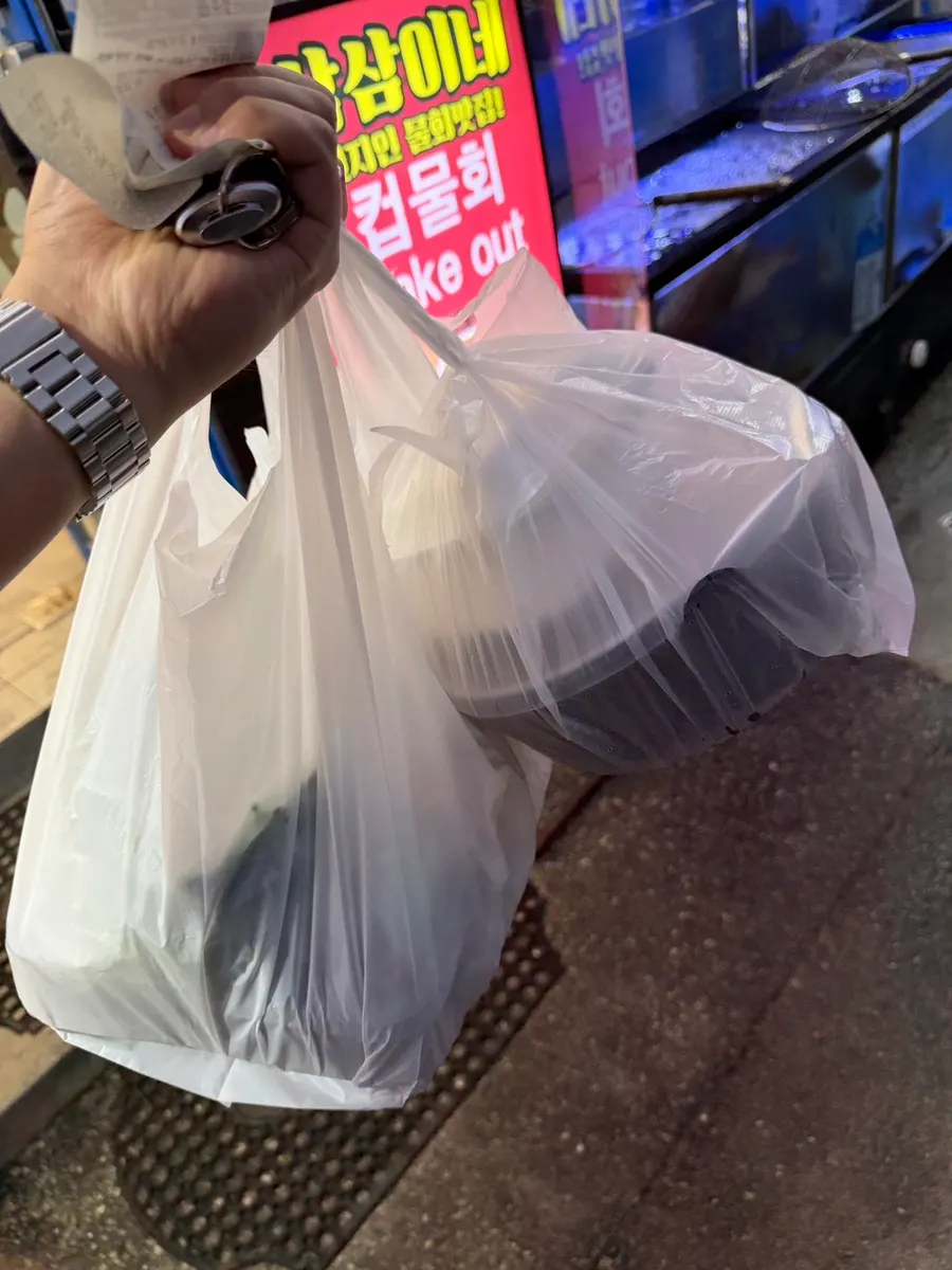 Takeout bag with the ₩70,000 value combo of assorted sashimi and mulhoe