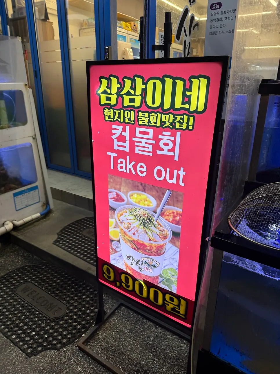 파란 조명 아래 활어가 헤엄치는 수족관