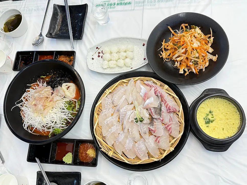 밥 위에 회와 무침, 묵은지를 올린 한 입