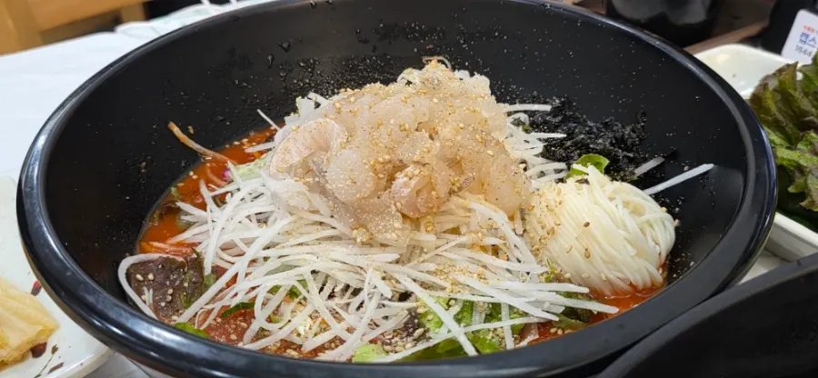 A bowl of mulhoe with shaved ice floating in the broth