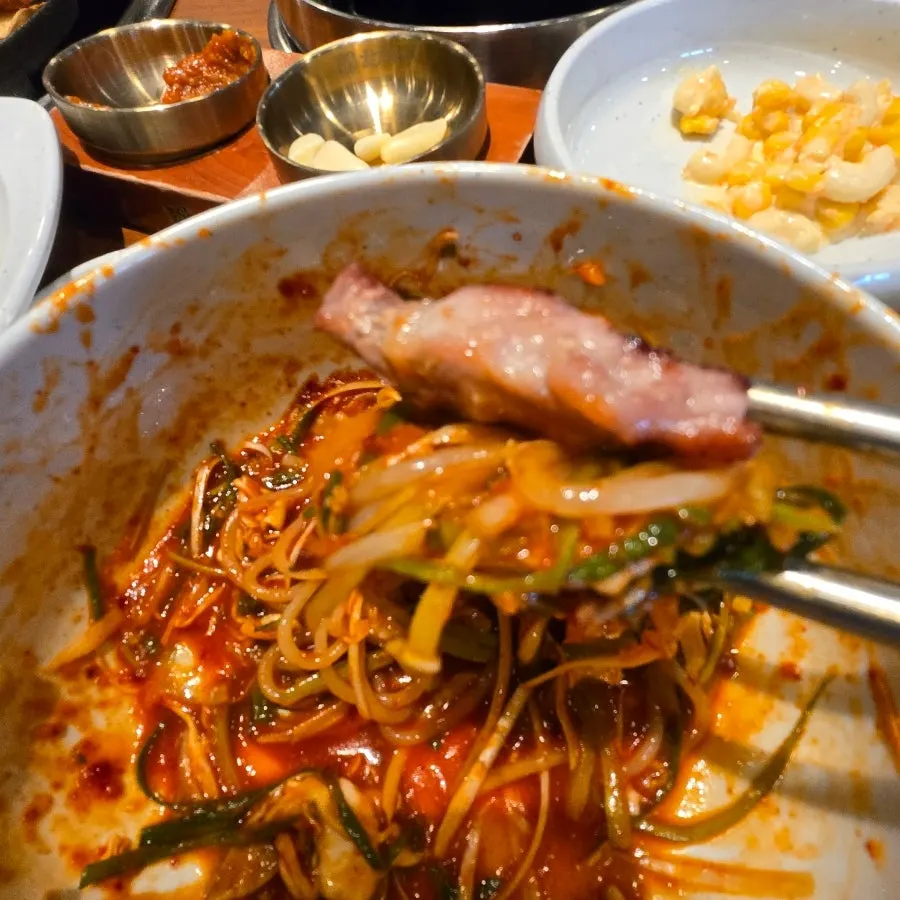 Tangy, spicy jjolmyeon eaten with pork