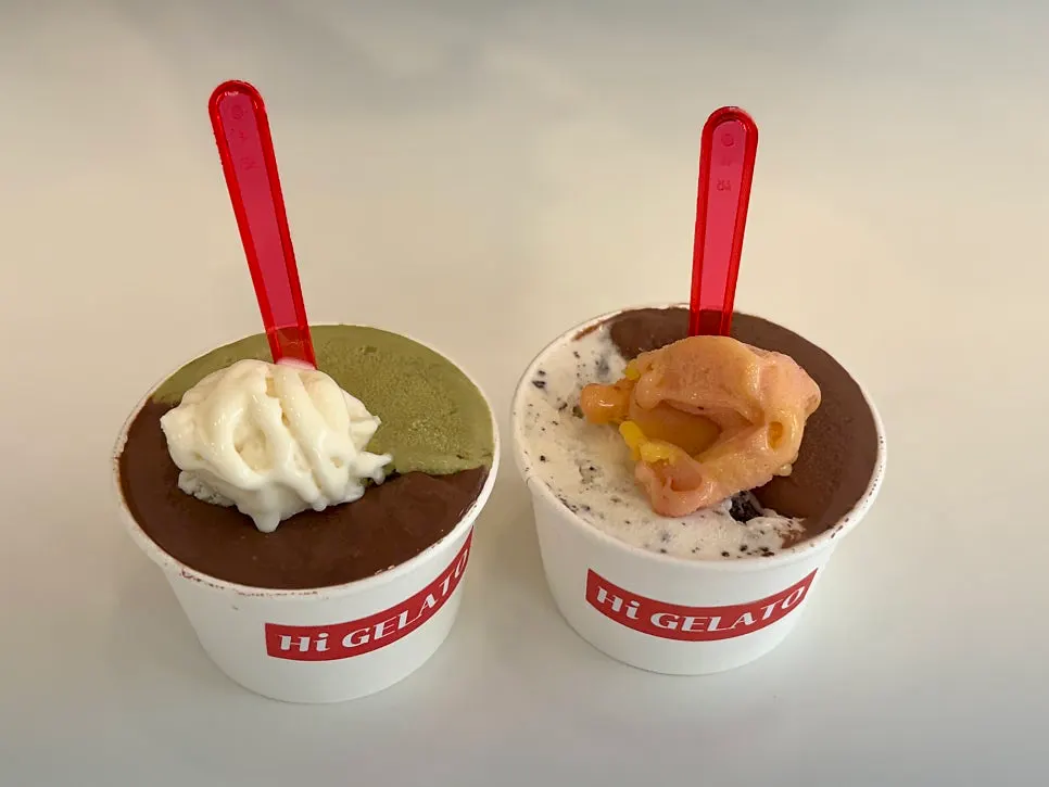 Two large gelato cups topped with taste spoons