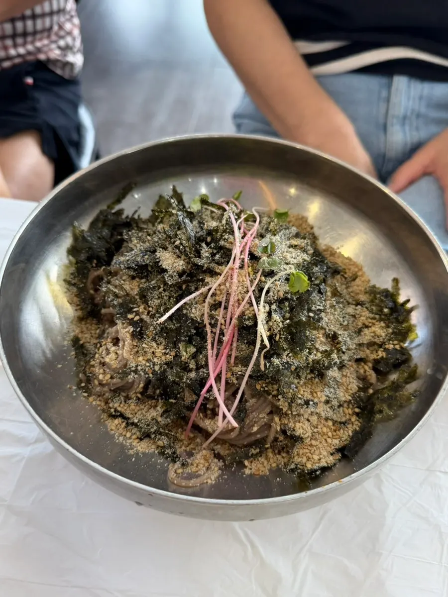 Perilla oil makguksu topped generously with seaweed flakes