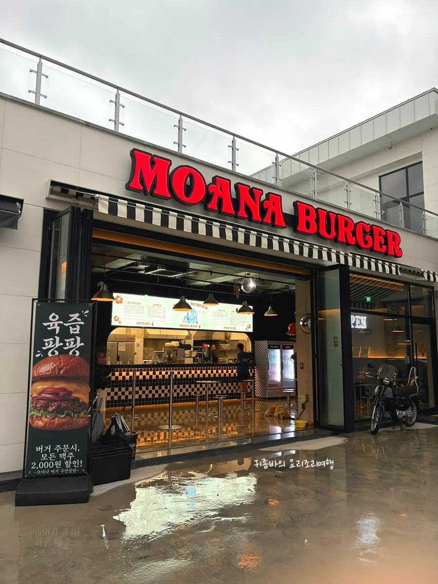 Exterior of Moana Burger's standalone building with folding doors open