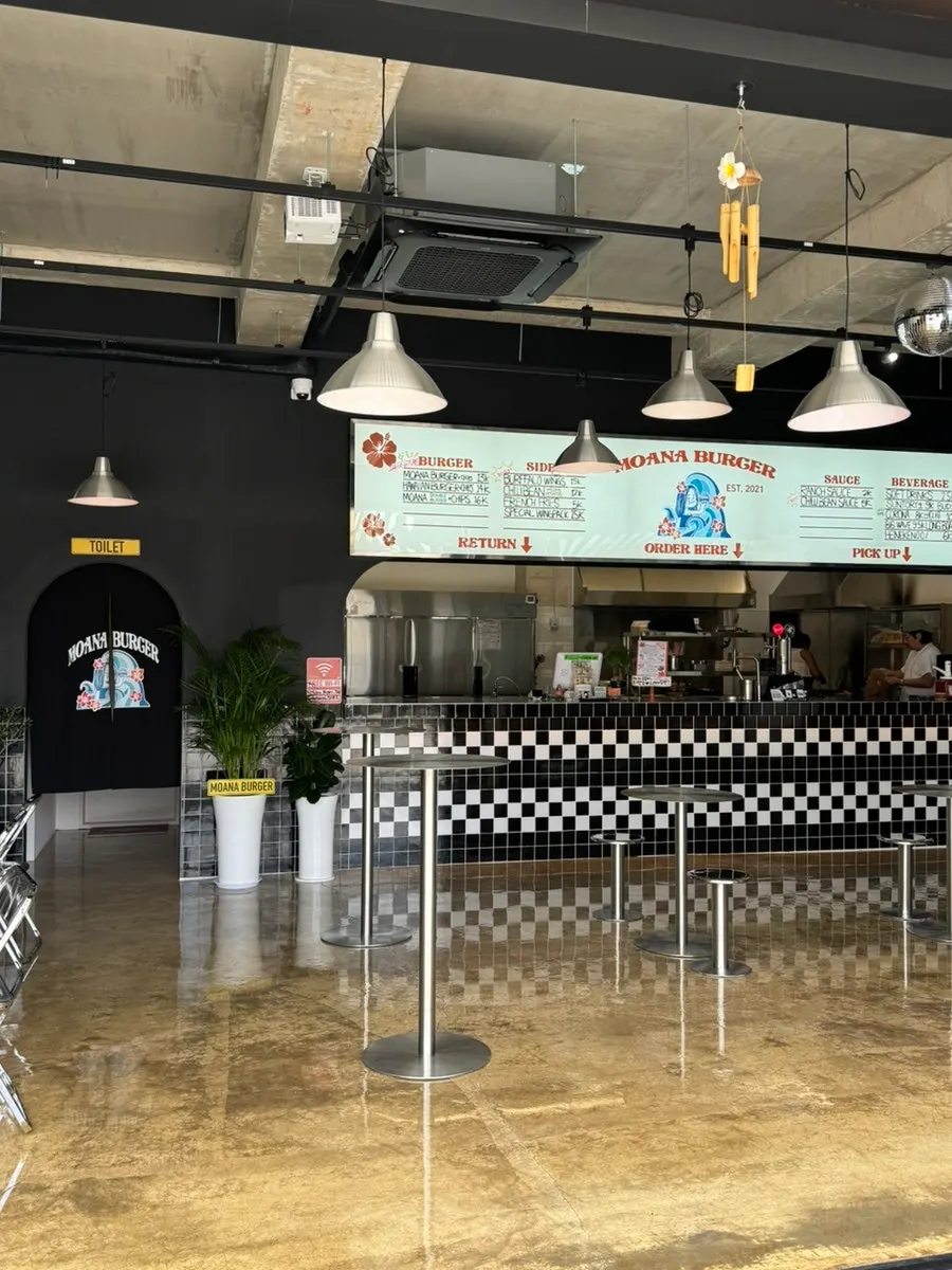 Moana Burger's interior decorated in black tones with checkerboard tiles