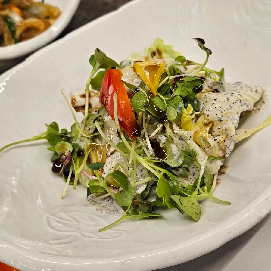 Plate of broccoli, sweet pumpkin salad, japchae and other side dishes