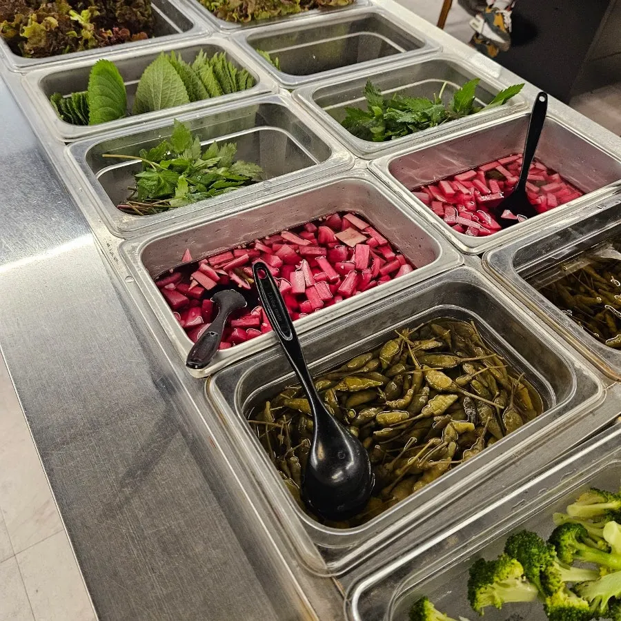 Self-serve corner with wrap vegetables and side dishes at Chodang Uga