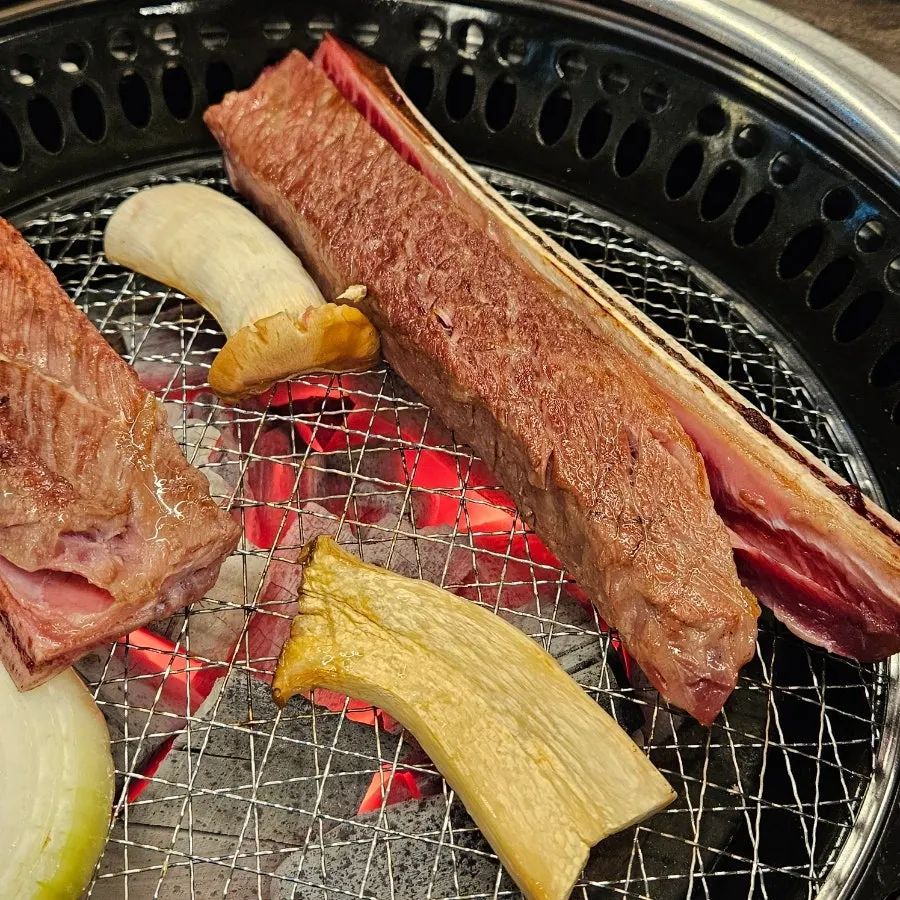 Woo-dae galbi placed on the charcoal grill
