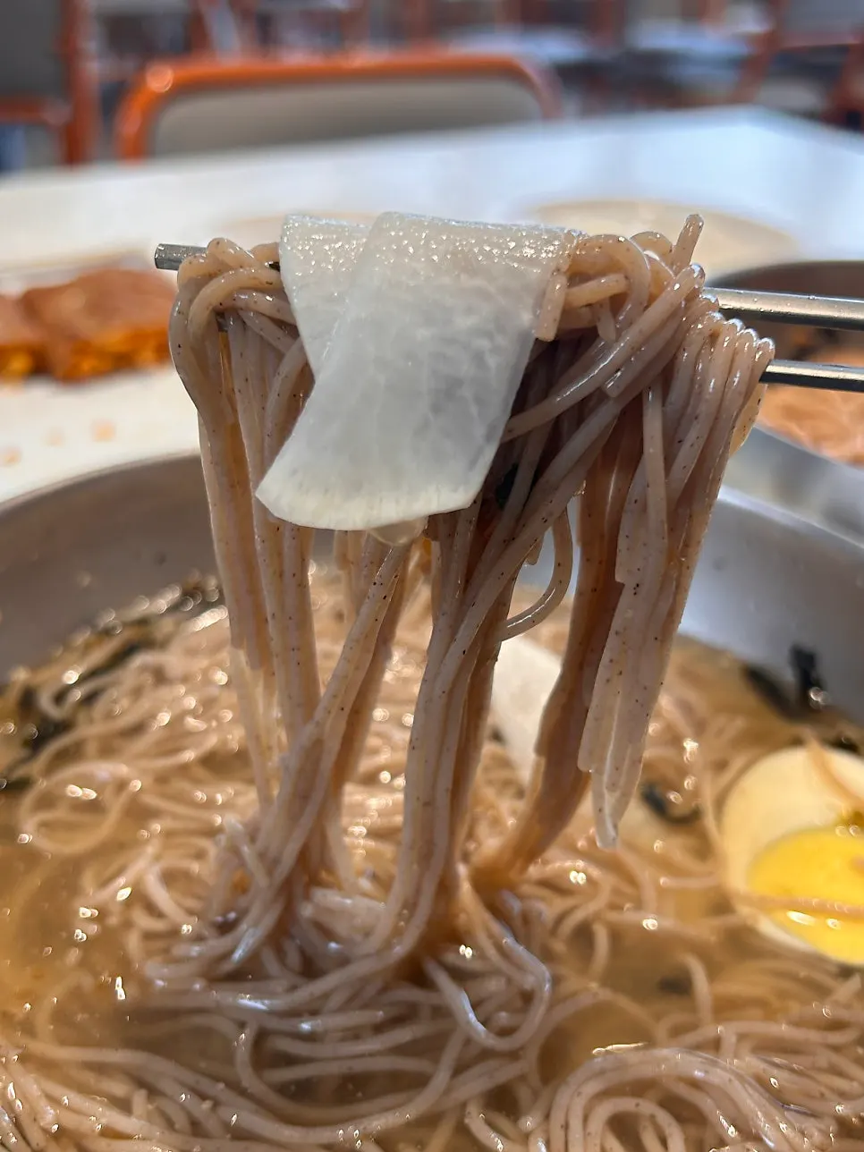Makguksu with dongchimi broth poured over it