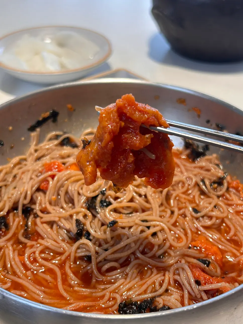 Hoe-makguksu topped with seasoned raw pollack