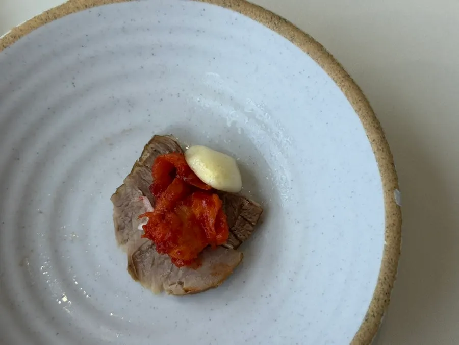 A piece of boiled pork topped with pollack sashimi