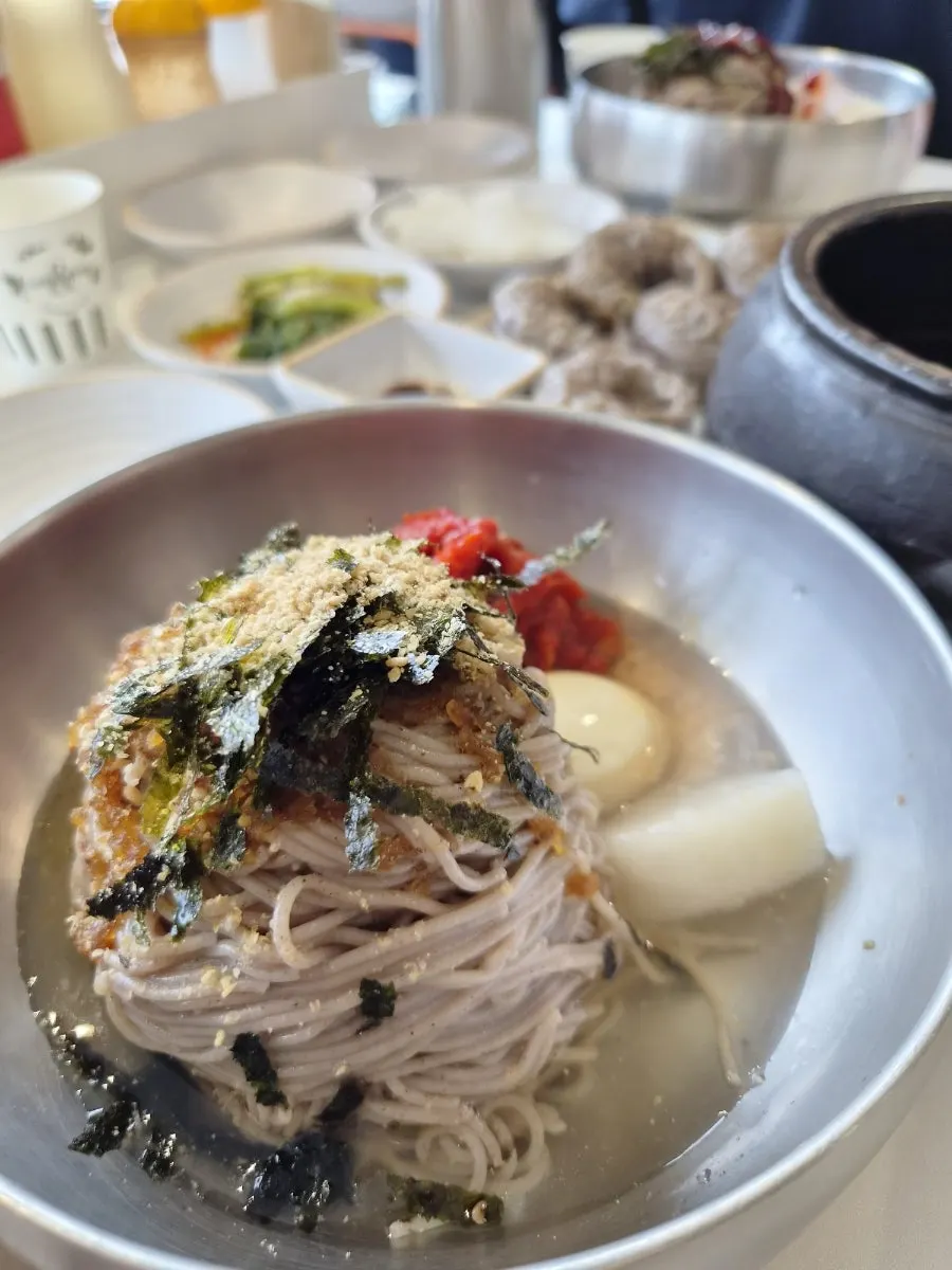A bowl of pollack sashimi makguksu topped with sashimi
