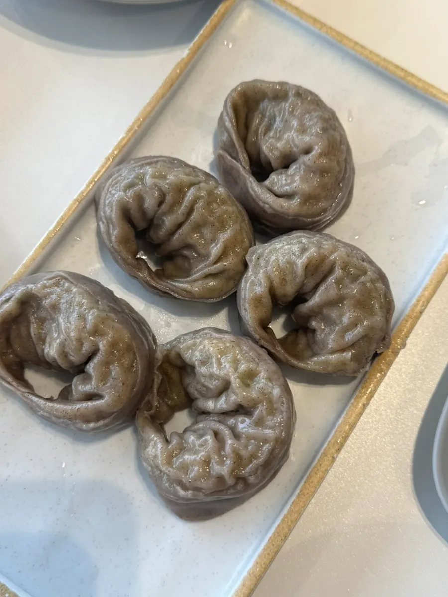 A bite of makguksu topped with pollack sashimi