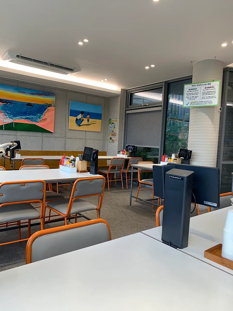 Paintings displayed on the wall next to tables
