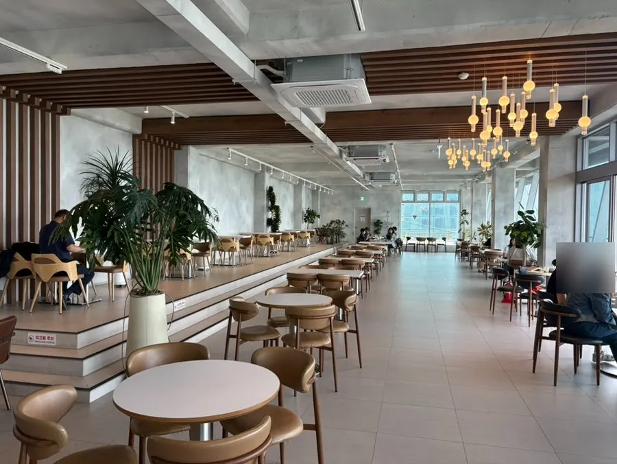 White and wood-toned interior with the sea visible through floor-to-ceiling windows