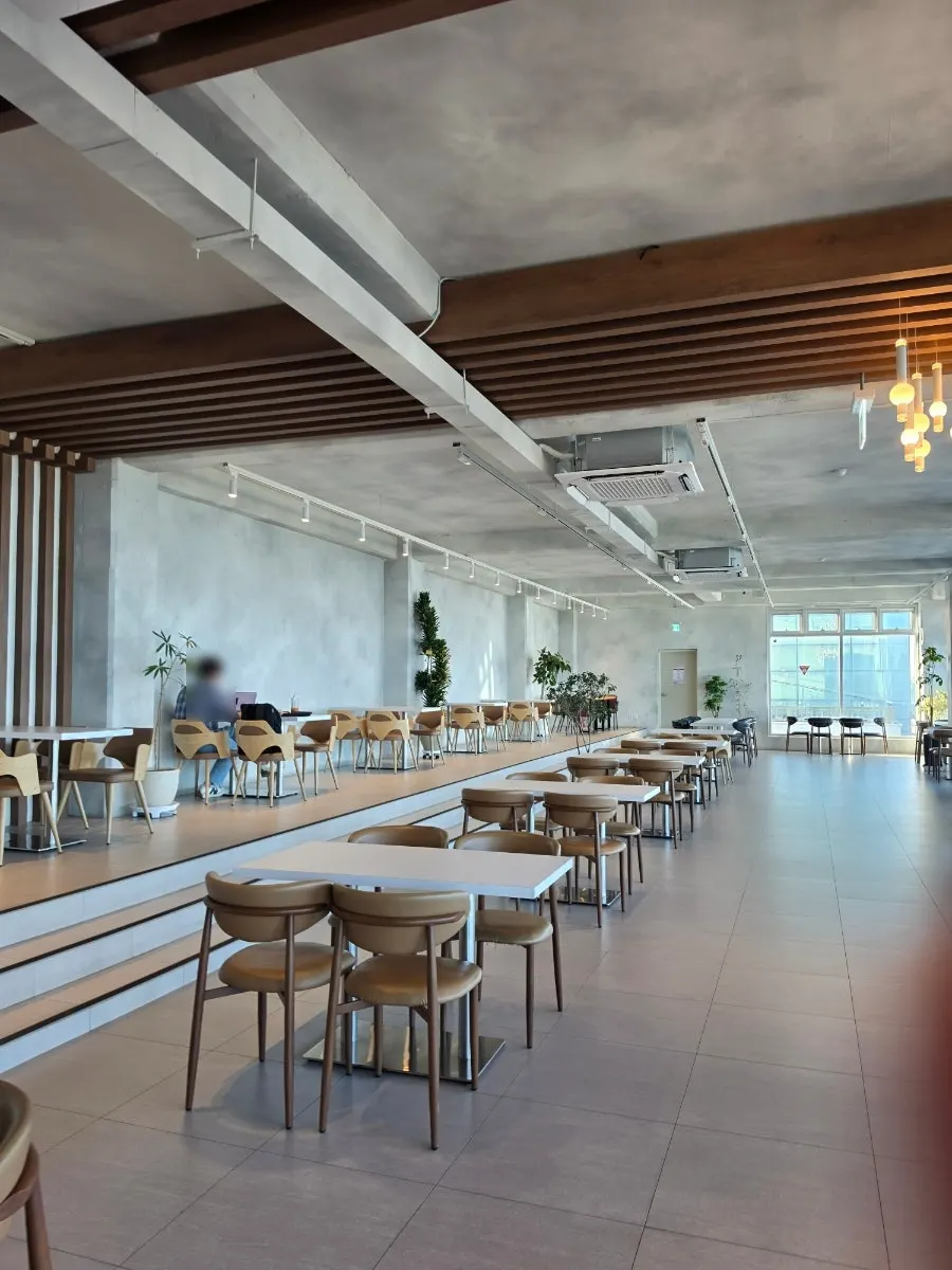 3rd-floor seating at Baegya Coffee with the sea outside the window