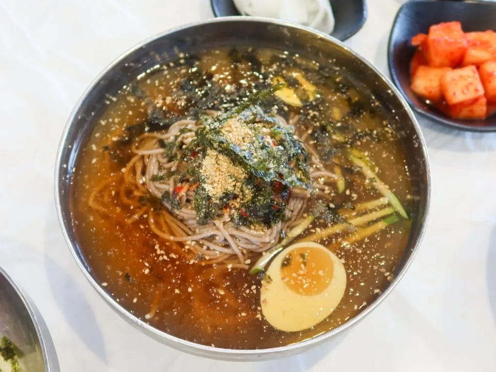 Buckwheat noodles topped with shredded seaweed and perilla seed powder