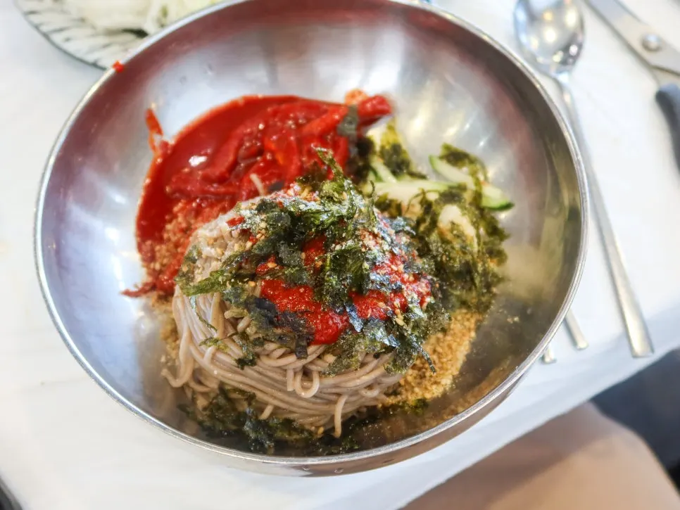A bowl of spicy mixed makguksu with fermented pollock