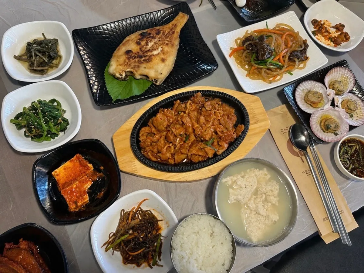 Table packed full with the 17-dish set at Saimdang Bueok