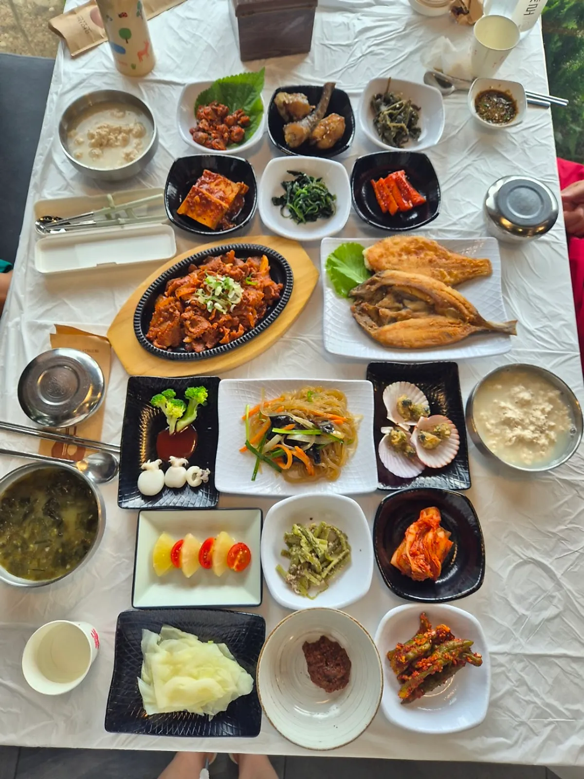 Table with stir-fried pork, grilled fish, and buttered scallops