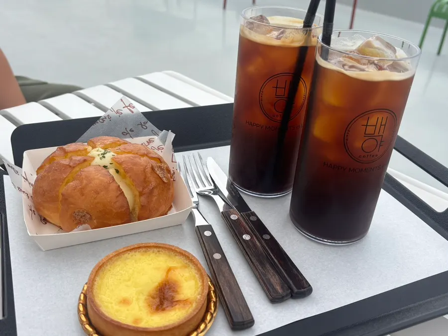 Table setting with Americano, egg tart, and garlic cream bread