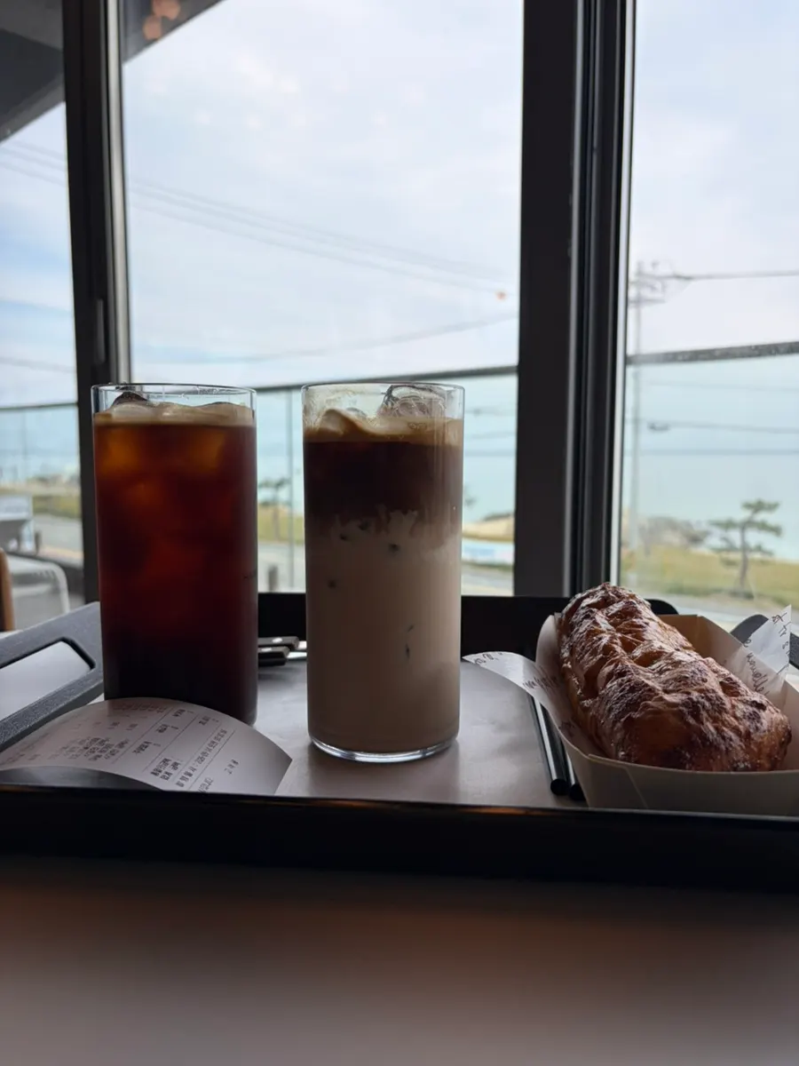 Iced americano and latte placed at a window seat