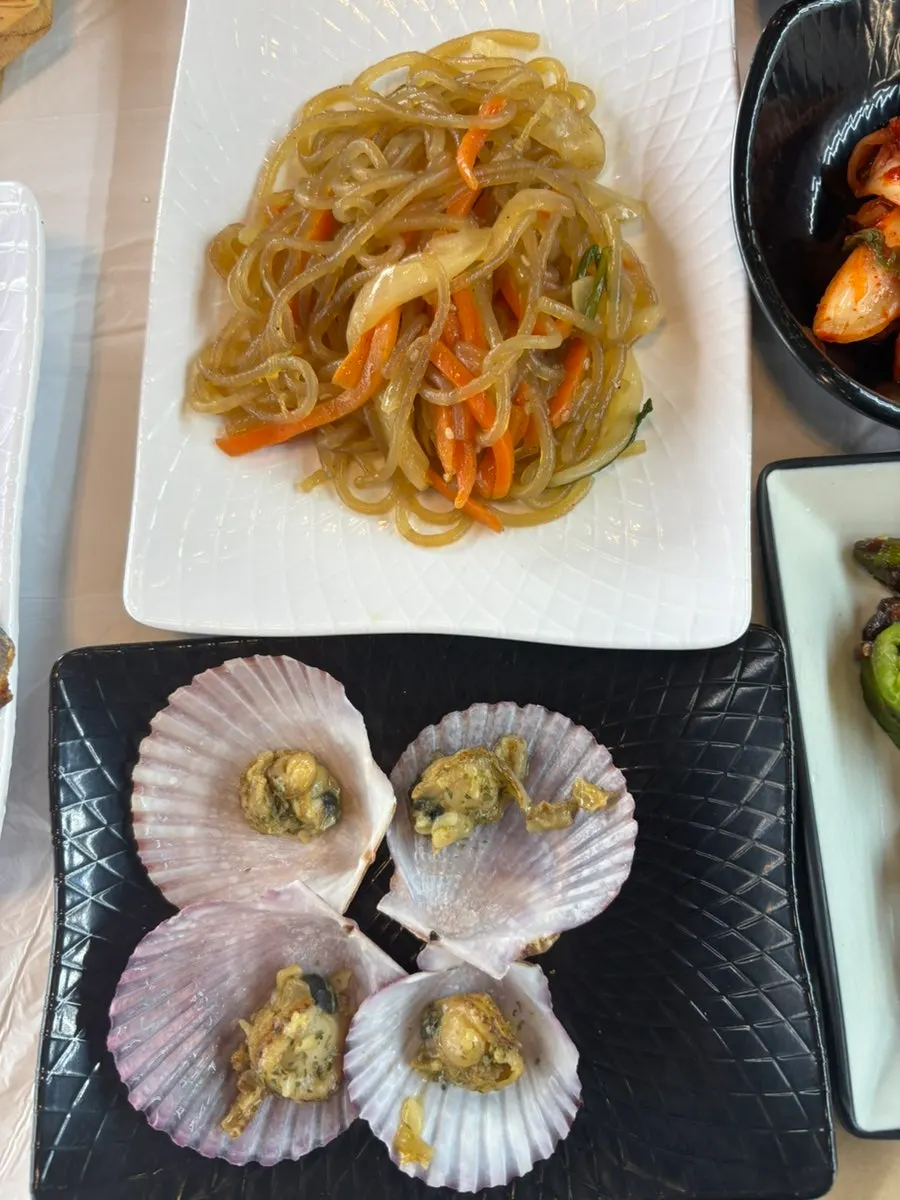Side dishes including steamed scallops and japchae