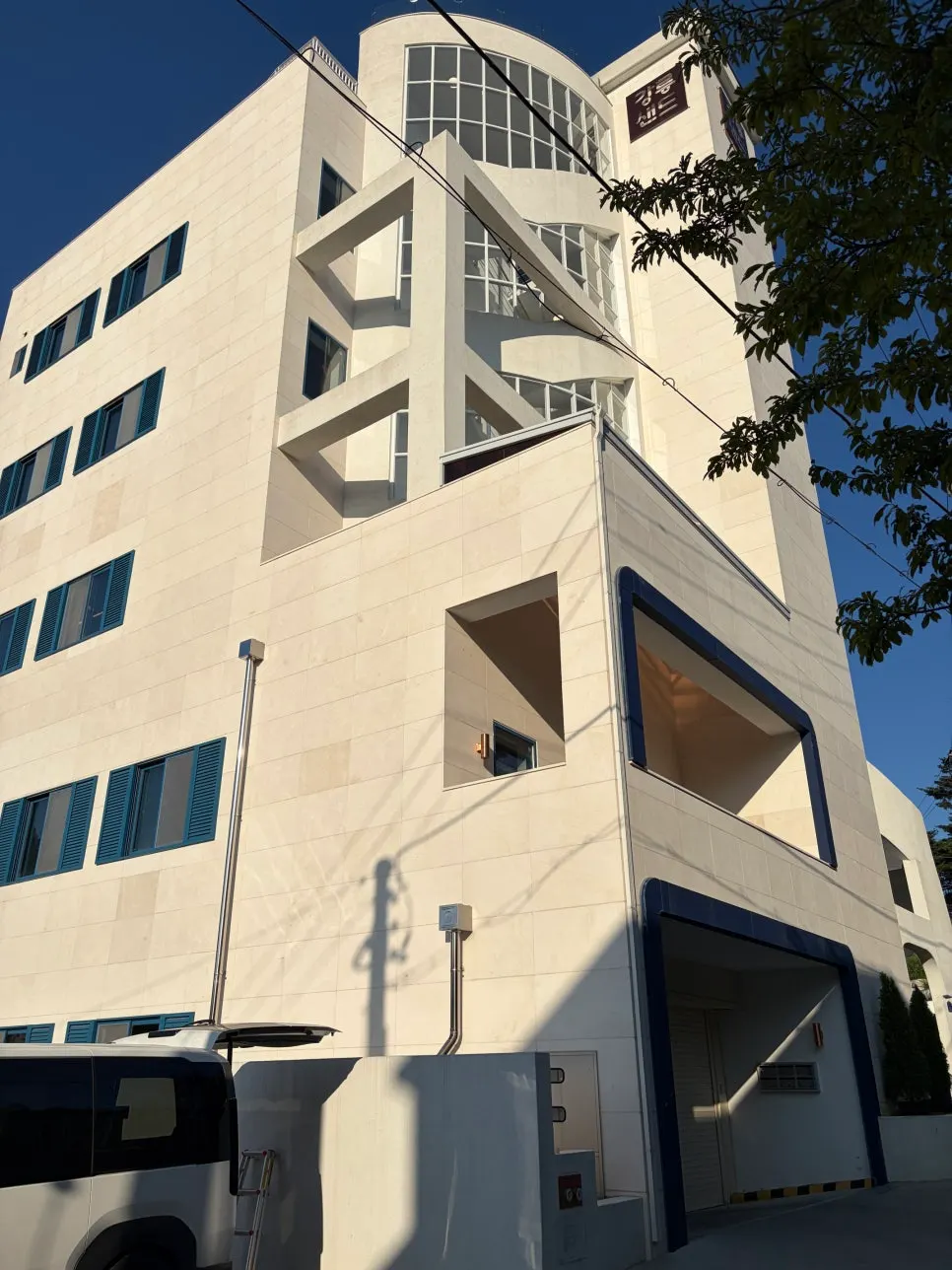 흰 벽에 딥블루 포인트를 준 강릉샌드 본점 건물 외관