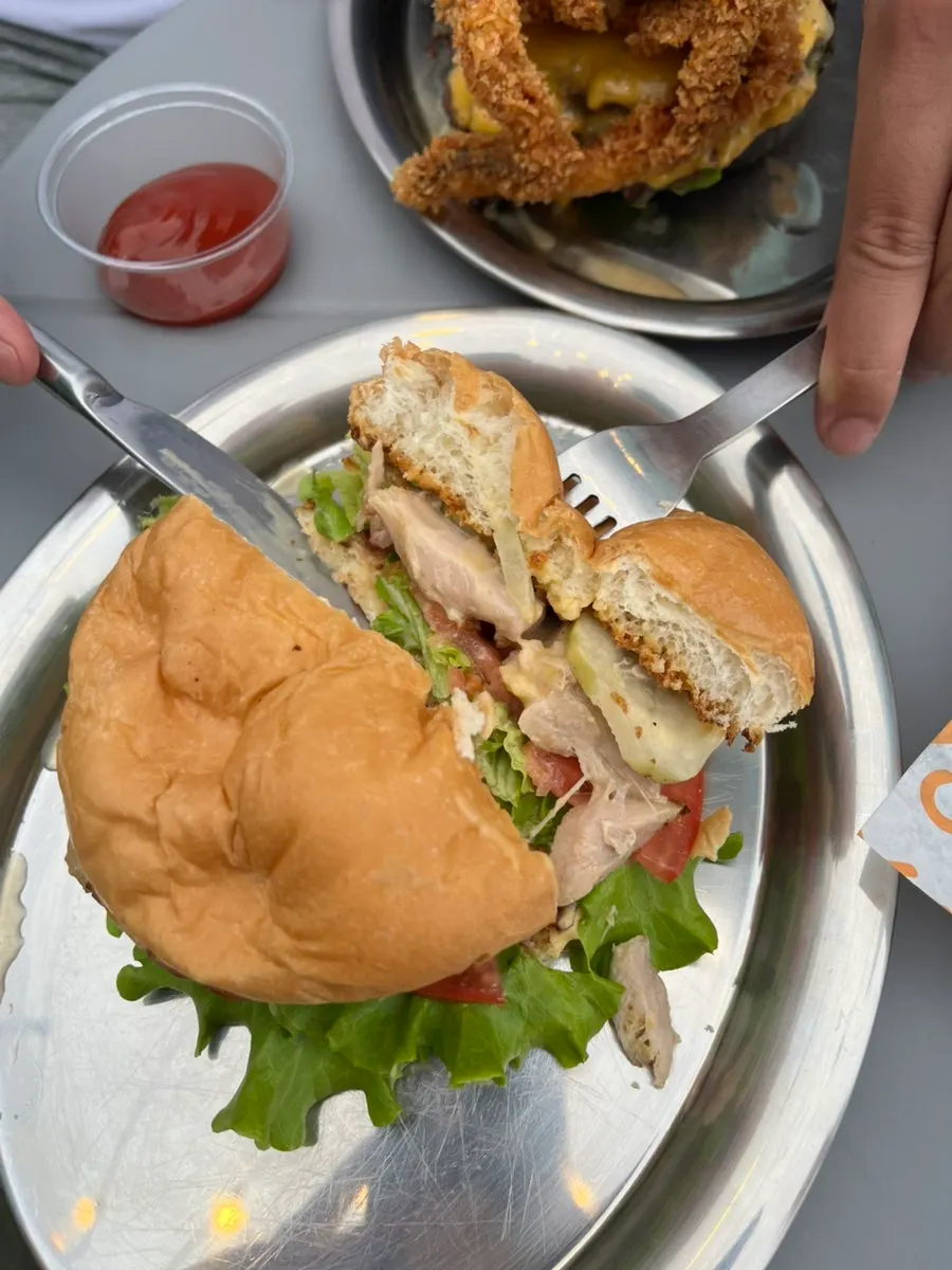 Table spread of handmade burgers at Burger Bar with a sea view