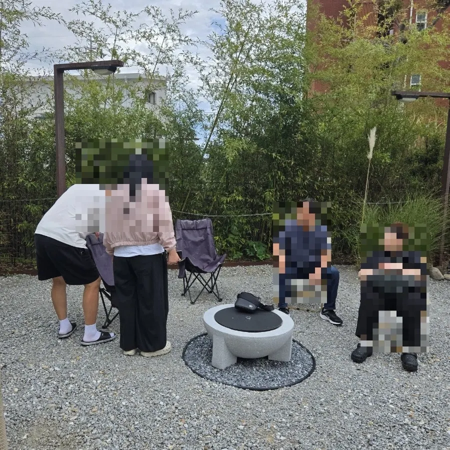 Family gathered around the fire pit zone in the Yeongjin-gil 51 yard