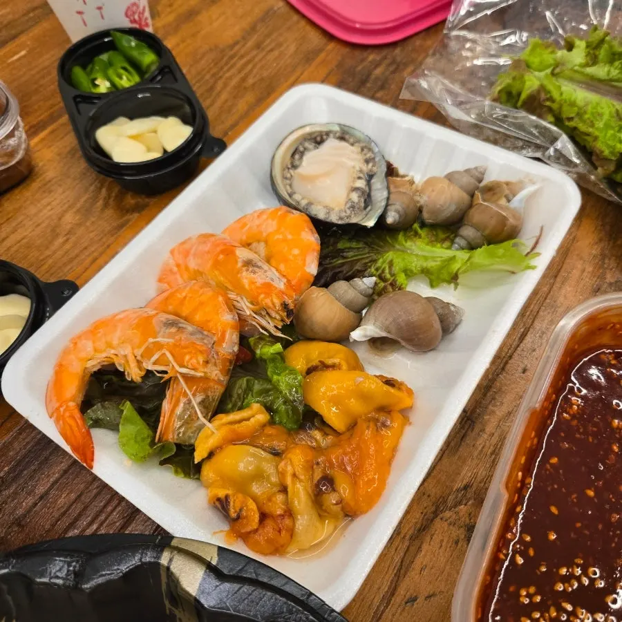 Dinner table with raw fish and Manseok Dak-gangjeong