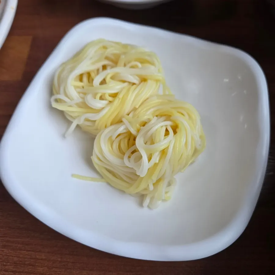 Thin noodles served alongside the mulhoe