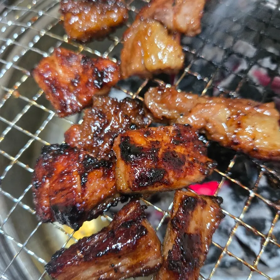 Charcoal-grilled pork ribs turning golden