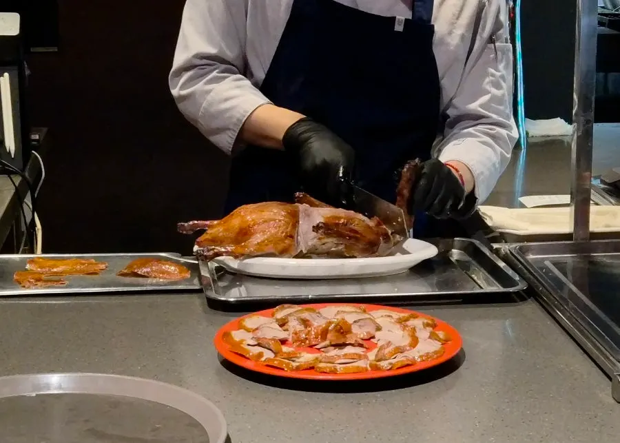 Table with Peking duck and spicy eggplant rice bowl together