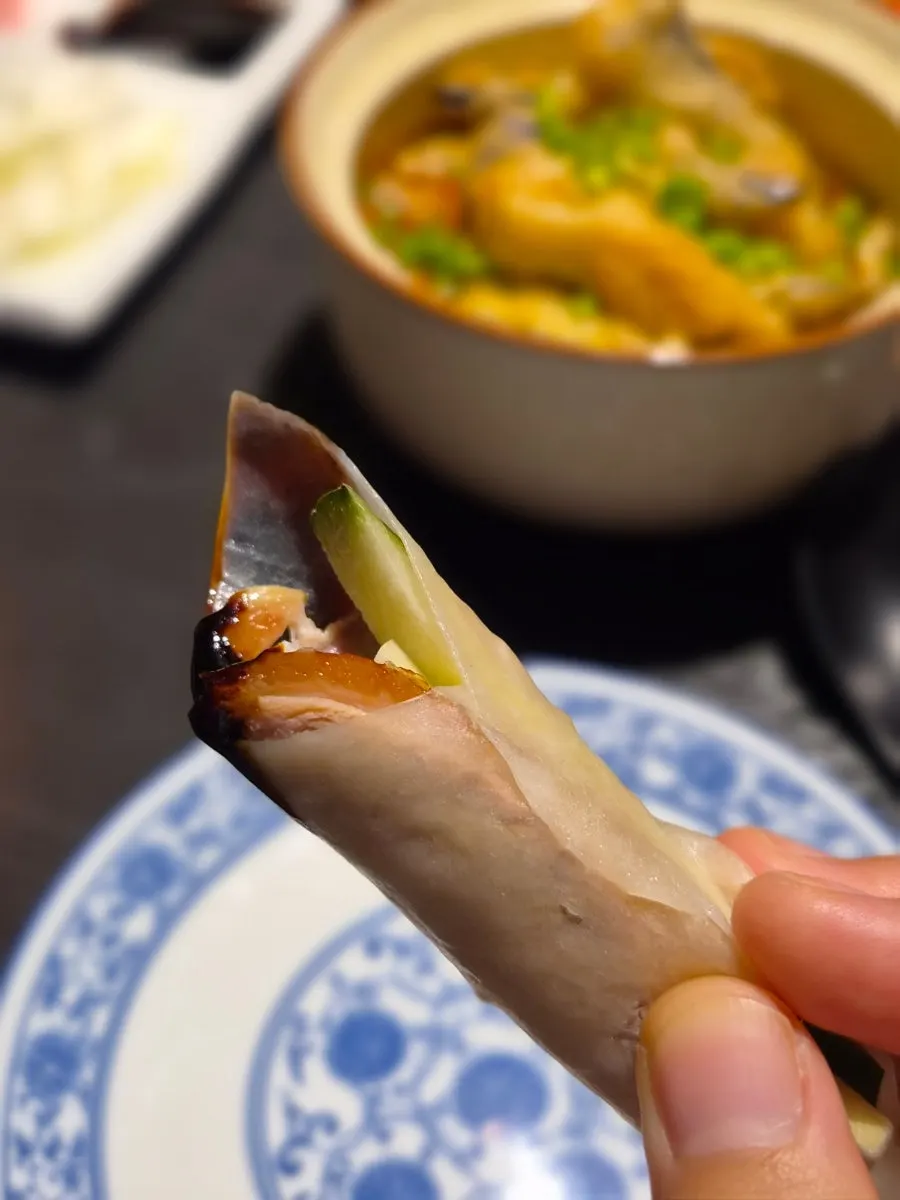 Duck meat wrapped in a pancake with cucumber and scallion