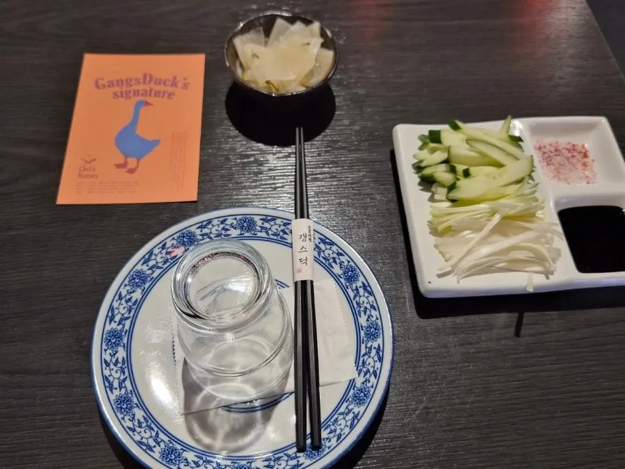 Basic table setting with pickled radish, cucumber, scallion, yajang sauce, and sugar