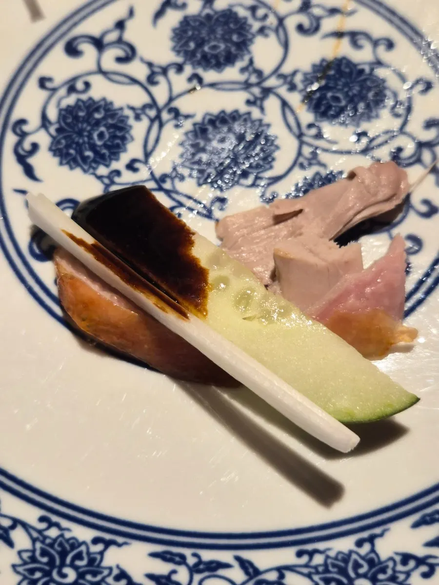 Peking duck meat topped with cucumber and scallion, without a pancake