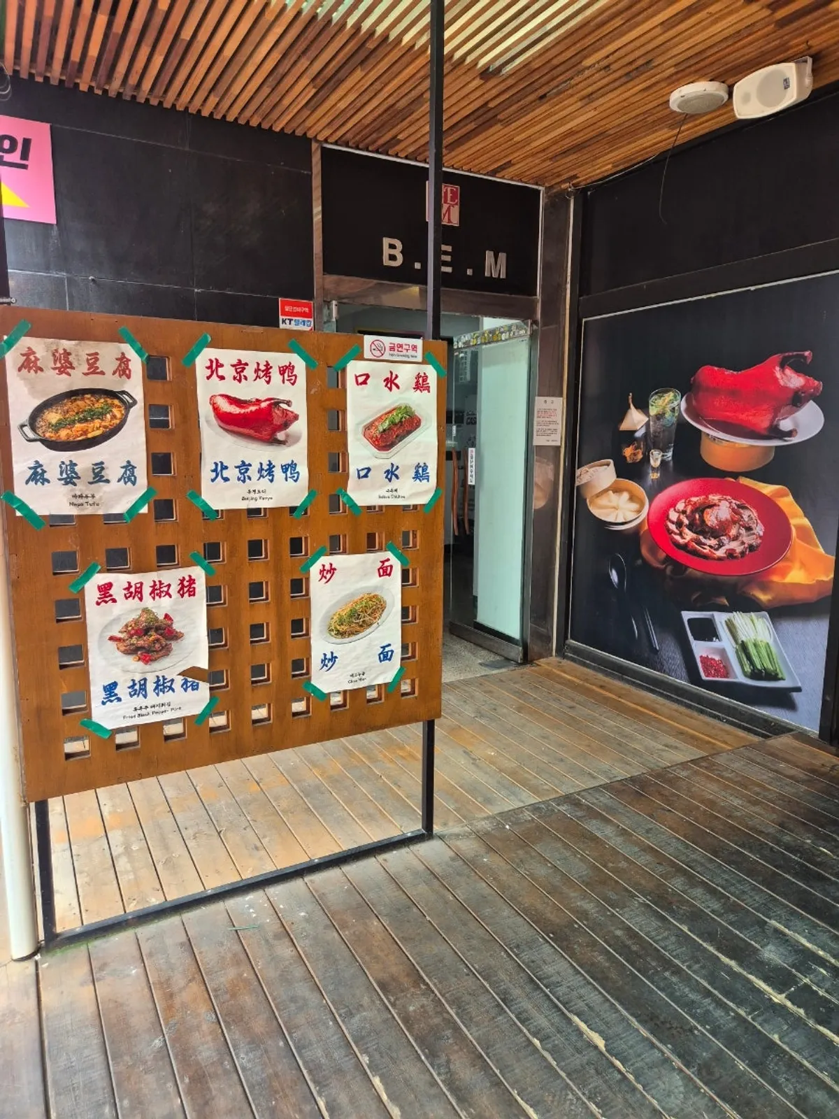 Signature menu photos and Chinese-character signage at the entrance of Gang's Duck