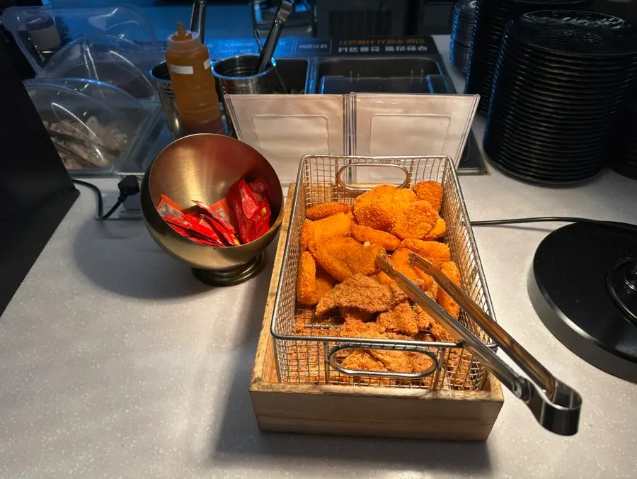 Self-serve bar food including hash browns and seasoned chicken