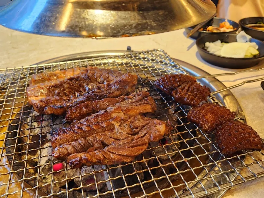 Seasoned galbi and pork skin on the grill