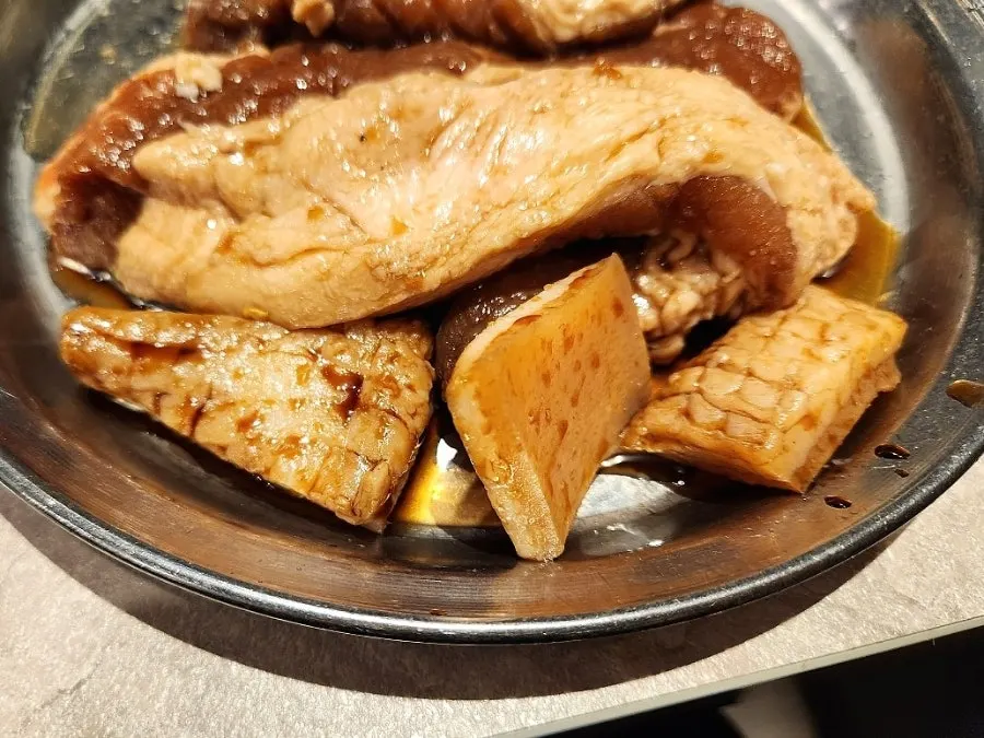 Grill plate loaded with seasoned pork ribs and pork skin