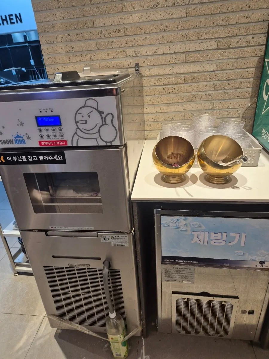 Self-serve drink corner with plum drink and orange juice
