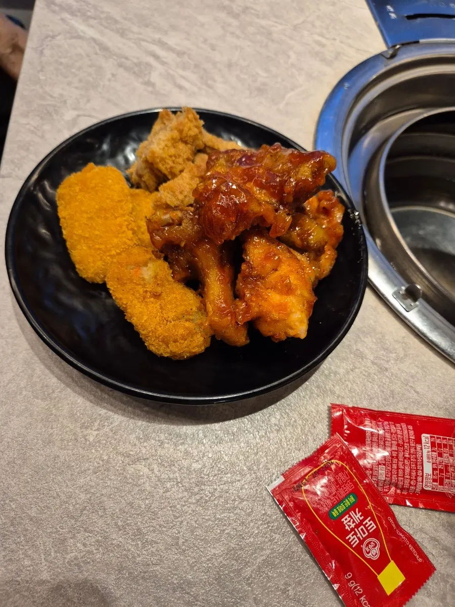 Fried food and chicken from the self-serve bar with vegetables set up on the table