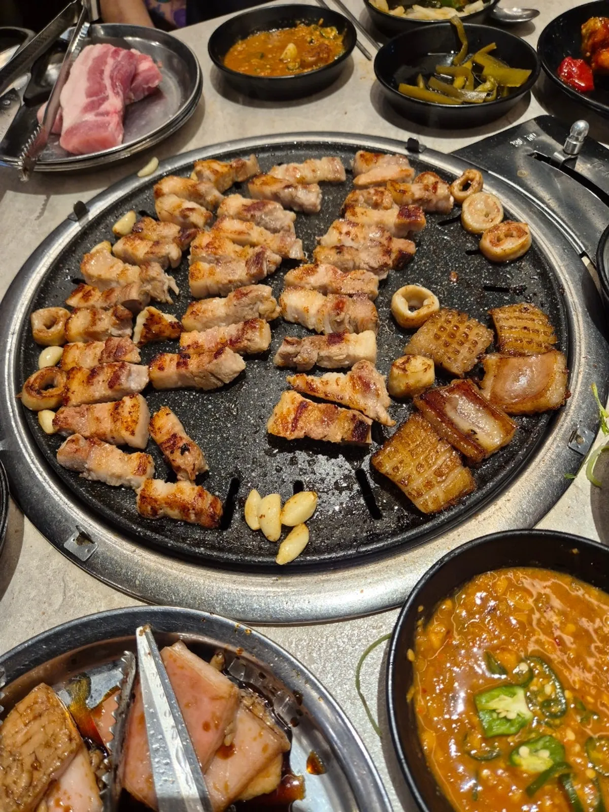 Domestic pork belly laid out on the round grill plate