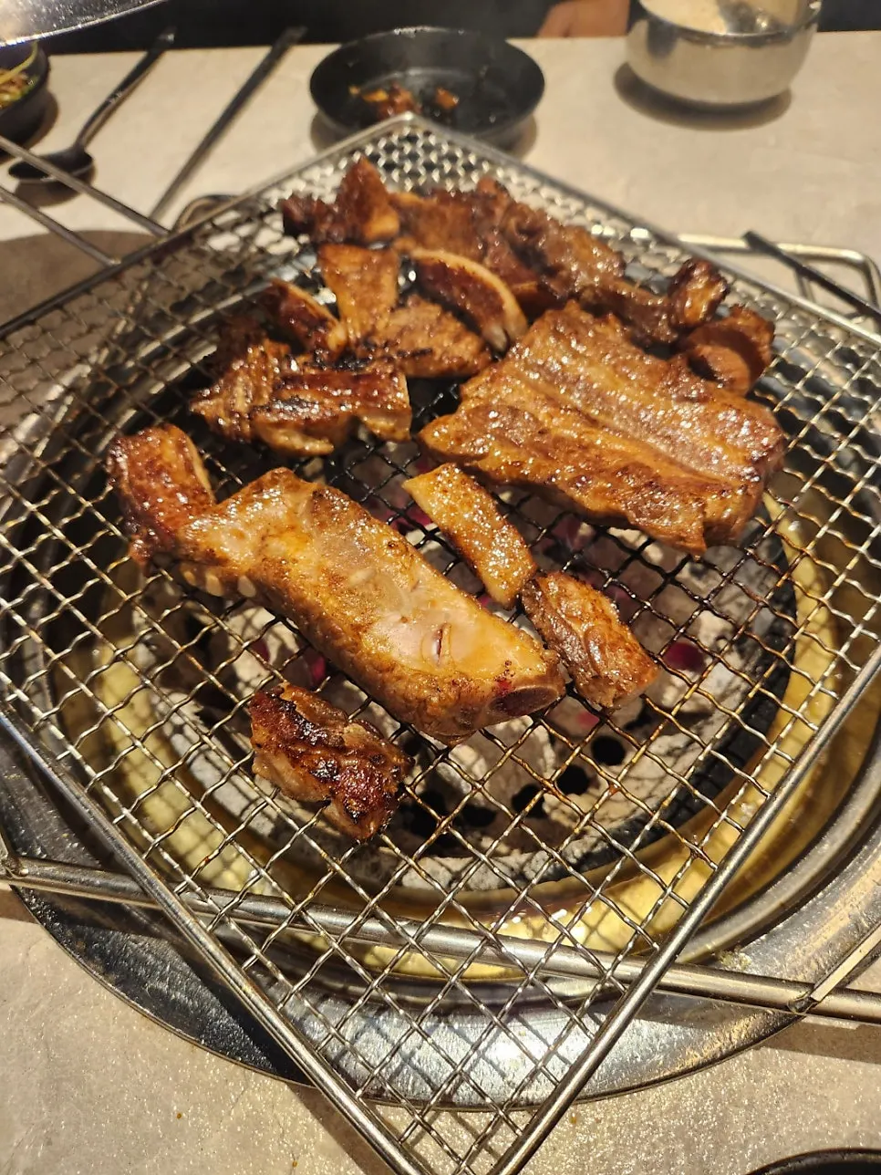 Bone-in pork ribs grilling on the pan