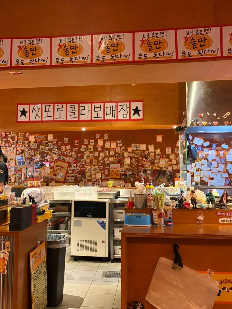 Open kitchen in the center with flyers on the wall