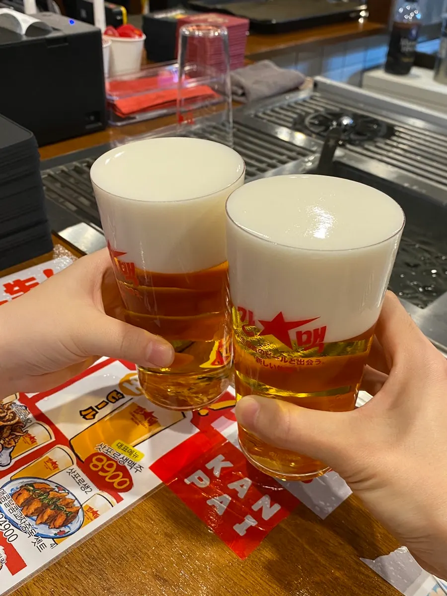 A glass of Sapporo draft held in hand